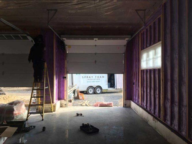 purple spray foam insulation in progress within garage