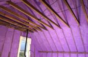 purple spray foam insulation covering walls and roof of farm house