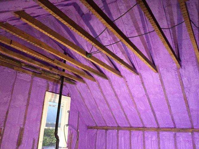 purple spray foam insulation covering walls and roof of farm house