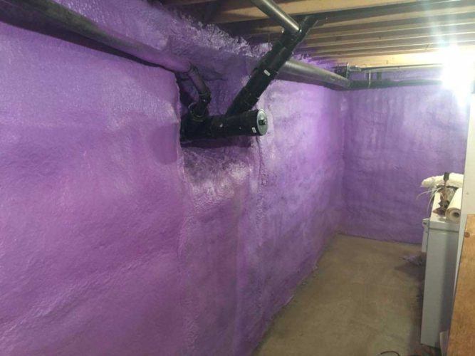 purple spray foam applied around pipes on basement walls