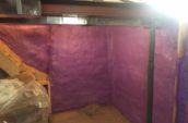 purple spray foam insulation covering walls of basement