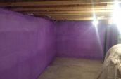 purple spray foam insulation covering walls of basement