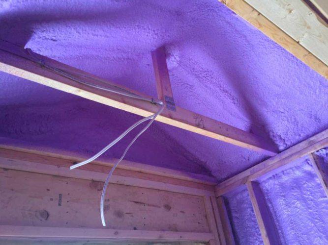 purple spray foam insulation covering roof of room