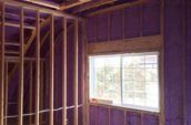Purple spray foam insulation on the framed walls of a building interior