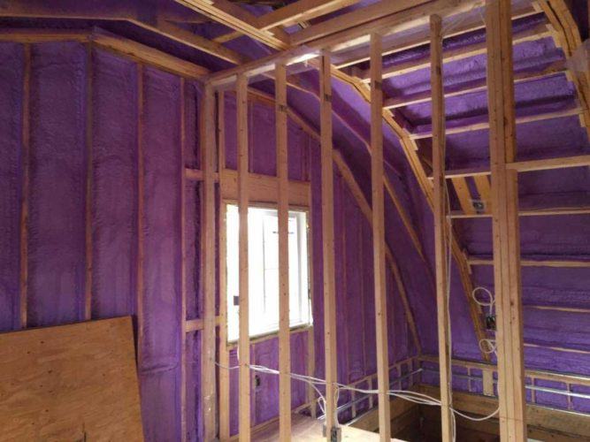 purple spray foam insulation covering walls and roof of house