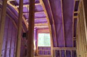 purple spray foam insulation covering walls and roof of house
