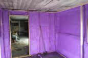 purple spray foam insulation inside framing of office walls