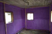 Purple spray foam insulation on the framed walls of an old outbuilding