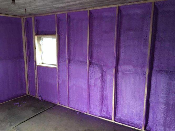 Purple spray foam insulation on the framed walls of an old outbuilding