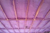 view of purple spray foam insulation for home floor from below